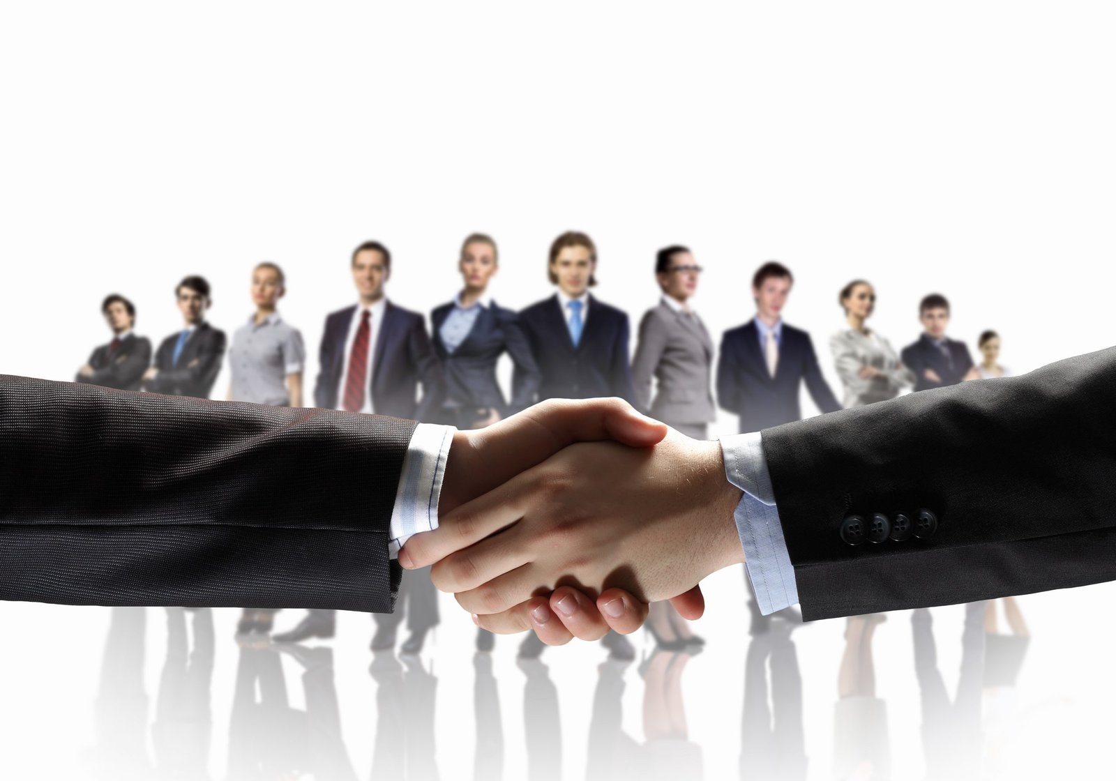 business handshake against white background and standing businesspeople